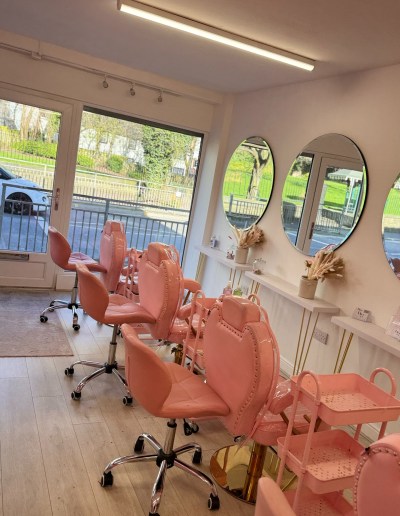 Inside the main entrance of an aesthetics salon, with numerous boutique-style mirrors and trendy furniture