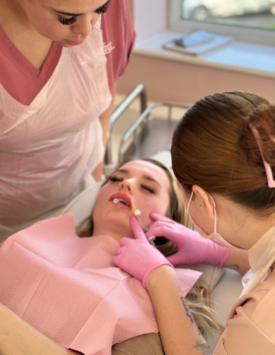A demonstration of how to carry out an aesthetic treatment, with one trainee aesthetician observing an experienced tutor