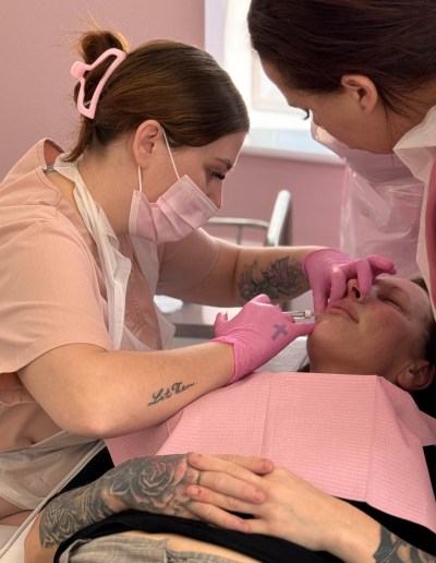 A demonstration of how to carry out an aesthetic treatment, with a trainee aesthetician observing an experienced tutor